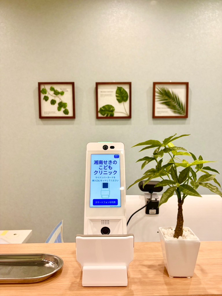 受付カウンター。セルフ受付端末と観葉植物